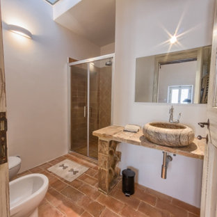 Idée de décoration pour un WC et toilettes style shabby chic avec un sol en carreau de terre cuite et une vasque.