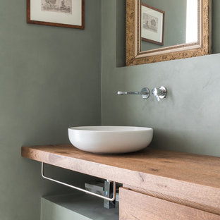 Foto di un bagno di servizio design con ante lisce, ante in legno scuro, pareti grigie, lavabo a bacinella e top in legno