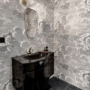 Idee per un bagno di servizio minimal con ante nere, pavimento nero, top nero e lavabo integrato