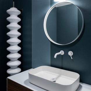 Ispirazione per un bagno di servizio design di medie dimensioni con ante lisce, ante in legno scuro, pareti blu, lavabo a bacinella, top bianco e mobile bagno incassato