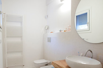 Idee per un piccolo bagno di servizio minimal con WC a due pezzi, piastrelle bianche, piastrelle a mosaico, pareti bianche, parquet chiaro, lavabo a bacinella, top in legno e top marrone