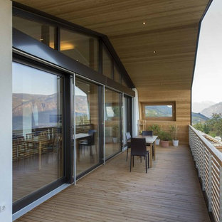 Foto di un balcone moderno con un giardino in vaso, un tetto a sbalzo e parapetto in legno