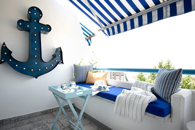 Esempio di un balcone stile marinaro con un parasole