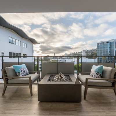Balcony - large contemporary balcony idea in Los Angeles with a roof extension and a fire pit