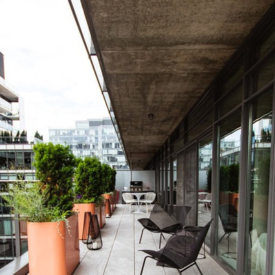 Example of a small trendy glass railing and apartment balcony design in Toronto with a roof extension