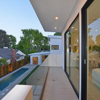 Inspiration for a mid-sized contemporary balcony remodel in Los Angeles with a roof extension