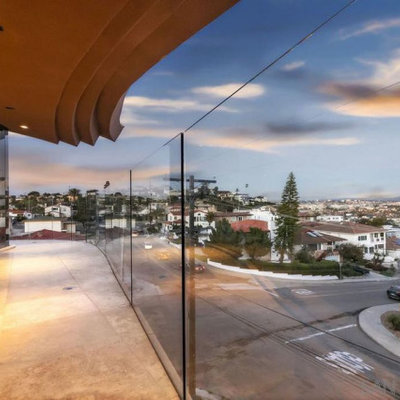 Example of a mid-sized trendy glass railing balcony design in San Diego with a roof extension