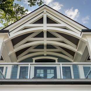 Example of a large arts and crafts mixed material railing balcony design in Detroit with a roof extension