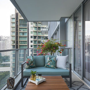 Immagine di un balcone d'appartamento design con un tetto a sbalzo e parapetto in materiali misti