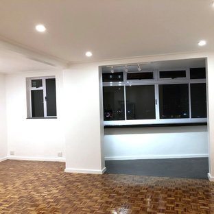 Aménagement d'un petit balcon moderne d'appartement avec une extension de toiture et un garde-corps en verre.
