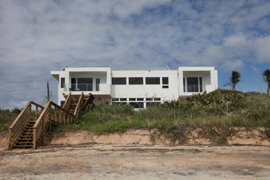 Cette image montre un balcon minimaliste de taille moyenne avec une extension de toiture et un garde-corps en métal.