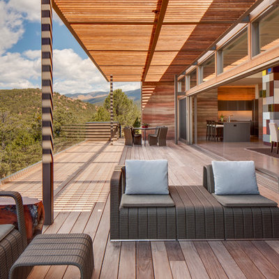 Inspiration for a large contemporary balcony remodel in Albuquerque with a roof extension