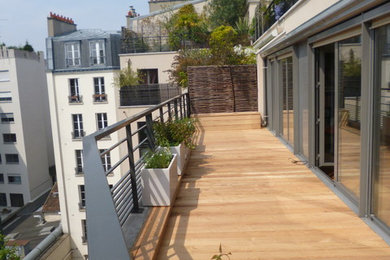 Réalisation d'un grand balcon design avec des plantes en pot, aucune couverture et un garde-corps en métal.