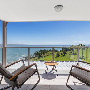 Contemporary balcony in Other with a roof extension and mixed railing.