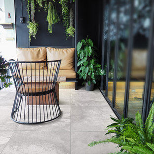 Exemple d'un balcon moderne de taille moyenne et d'appartement avec aucune couverture et un garde-corps en verre.