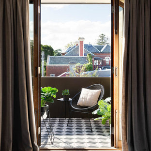 Photo of a mid-sized contemporary balcony in Melbourne with a roof extension and metal railing.