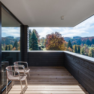 Überdachter Moderner Balkon mit Holzgeländer in München