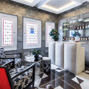 Modelo de bar en casa con barra de bar de galera, contemporáneo, de tamaño medio, con puertas de armario grises, salpicadero con efecto espejo, suelo multicolor y encimeras grises