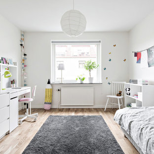 Inspiration för mellanstora moderna könsneutrala barnrum kombinerat med sovrum och för 4-10-åringar, med vita väggar och ljust trägolv