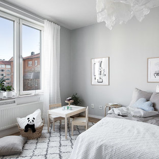 Inspiration för ett skandinaviskt könsneutralt barnrum kombinerat med sovrum, med grå väggar, mellanmörkt trägolv och brunt golv