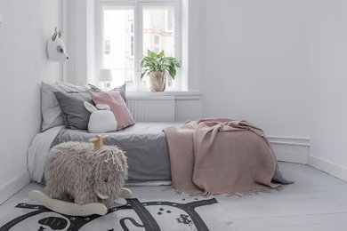 На фото: детская в скандинавском стиле с спальным местом, белыми стенами, деревянным полом и серым полом для ребенка от 4 до 10 лет, девочки
