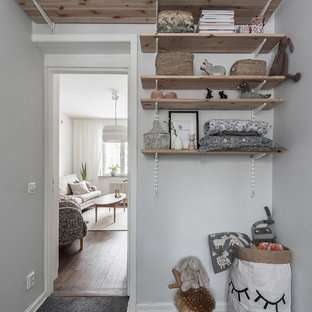 Inspiration för ett litet nordiskt könsneutralt barnrum kombinerat med lekrum, med grå väggar, heltäckningsmatta och grått golv