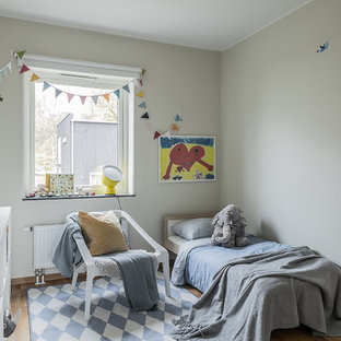 Foto på ett nordiskt könsneutralt barnrum kombinerat med sovrum och för 4-10-åringar, med beige väggar, ljust trägolv och beiget golv
