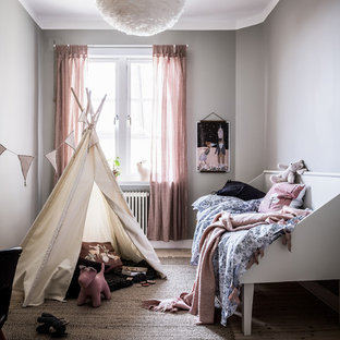 Minimalistisk inredning av ett mellanstort flickrum kombinerat med sovrum och för 4-10-åringar, med grå väggar, ljust trägolv och beiget golv