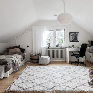 Foto på ett nordiskt könsneutralt tonårsrum, med mellanmörkt trägolv, vita väggar och brunt golv