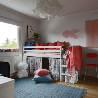 Idéer för nordiska flickrum för 4-10-åringar, med vita väggar, mellanmörkt trägolv och brunt golv