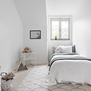 Idéer för ett mellanstort minimalistiskt könsneutralt barnrum kombinerat med sovrum och för 4-10-åringar, med vita väggar, ljust trägolv och beiget golv
