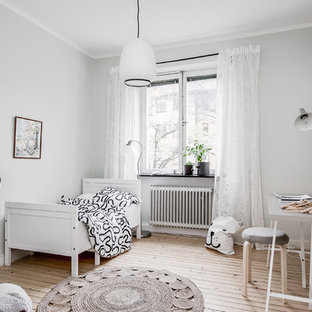 Exempel på ett minimalistiskt könsneutralt barnrum kombinerat med sovrum, med grå väggar, ljust trägolv och beiget golv