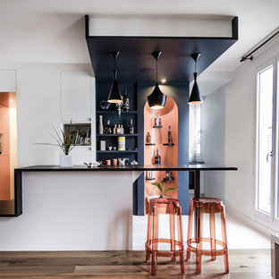 Idée de décoration pour un bar de salon linéaire design de taille moyenne avec un sol en bois brun, des tabourets et un placard sans porte.