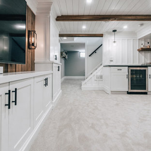 Design ideas for a mid-sized country fully buried basement in Minneapolis with a home bar, white walls, carpet, grey floor, wood and panelled walls.