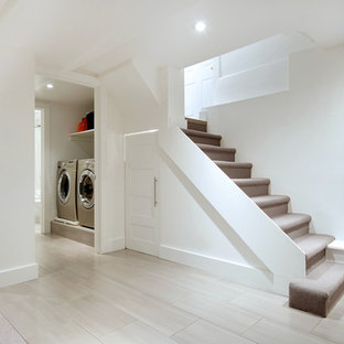 Cette image montre un petit sous-sol design semi-enterré avec un mur blanc, un sol en carrelage de porcelaine et aucune cheminée.