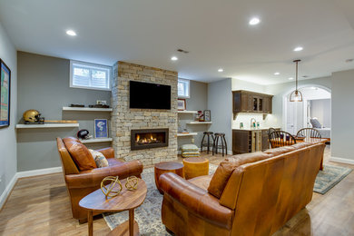 Basement - huge craftsman walk-out vinyl floor basement idea in DC Metro with a standard fireplace and a stone fireplace