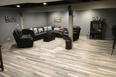 Example of a large farmhouse underground vinyl floor and gray floor basement design in Chicago with gray walls