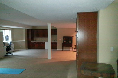Example of a huge classic walk-out carpeted basement design in Jackson with beige walls and no fireplace