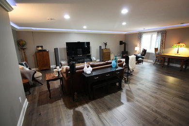Photo of a large modern walk-out basement in Minneapolis with grey walls, dark hardwood flooring and a standard fireplace.