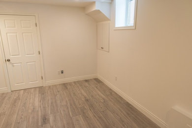Example of a small transitional underground dark wood floor and brown floor basement design in Toronto with beige walls and no fireplace