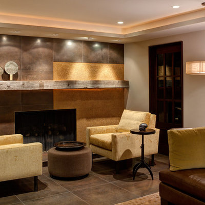 Trendy underground ceramic tile and brown floor basement photo in Chicago with beige walls, a standard fireplace and a tile fireplace