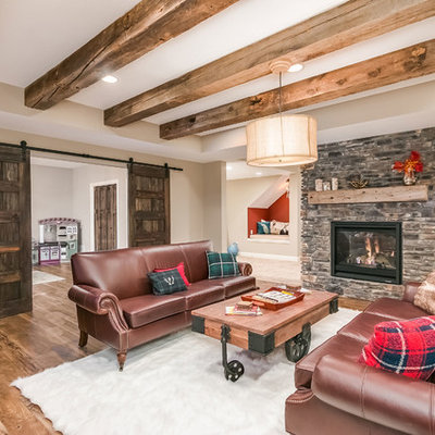 Basement - mid-sized rustic walk-out medium tone wood floor and brown floor basement idea in Minneapolis with beige walls, a two-sided fireplace and a stone fireplace