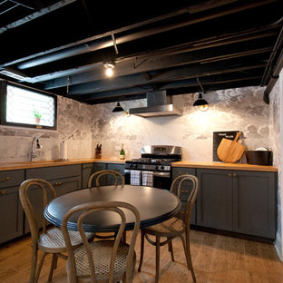 Réalisation d'un sous-sol champêtre semi-enterré et de taille moyenne avec un mur gris, un sol en bois clair, un sol marron, un bar de salon, un plafond en poutres apparentes et du papier peint.