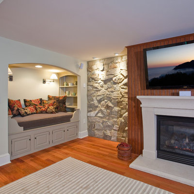 Example of a large classic walk-out medium tone wood floor basement design in Philadelphia with a standard fireplace and a stone fireplace