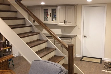 Example of a mid-sized trendy medium tone wood floor basement design in Other with beige walls