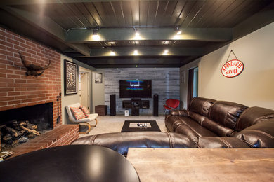 Example of a southwest look-out carpeted and beige floor basement design in Portland with multicolored walls, a standard fireplace and a brick fireplace