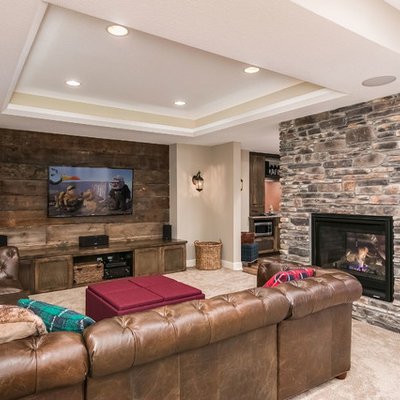 Basement - mid-sized rustic walk-out medium tone wood floor and brown floor basement idea in Minneapolis with beige walls, a two-sided fireplace and a stone fireplace