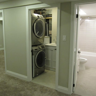 Idées déco pour un petit sous-sol moderne enterré avec un mur gris, moquette, cheminée suspendue, un manteau de cheminée en pierre et un sol gris.