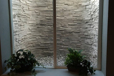デンバーにある中くらいなトラディショナルスタイルのおしゃれな地下室 (ベージュの壁、カーペット敷き、標準型暖炉、石材の暖炉まわり) の写真