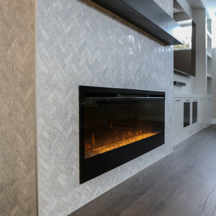 Cette photo montre un sous-sol tendance enterré avec un bar de salon, un mur blanc, un sol en bois brun, une cheminée standard, un manteau de cheminée en carrelage et du papier peint.